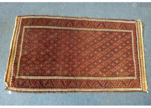 A woollen Baluch rug, terracotta hooked medallions on brown field, multiple geometric borders, 183