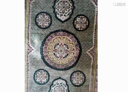 An attractive rug accented mostly in green with multiple repeating border patterns, the central