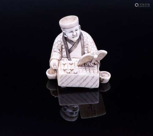 A Polychrome Carved Ivory Netsuke of a Go Player, …