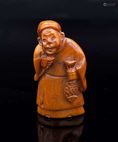 A Carved Stained Ivory Netsuke of a Fisherman, Sig…