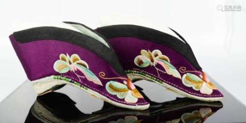 A pair of Chinese silk lotus shoes, circa 1920, the purple silk embroidered to depict butterflies,