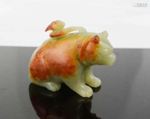 A Chinese Song Dynasty carved celadon coloured jade bear with man to his back, with rust coloured