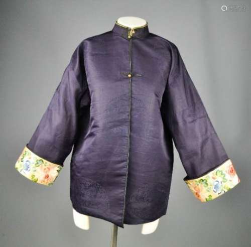 A Chinese silk ladies jacket in dark blue, with yellow lining, the sleeve panels embroidered with