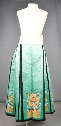 A Chinese silk skirt, circa 1920, hand embroidered to depict a five claw dragon, over mountains