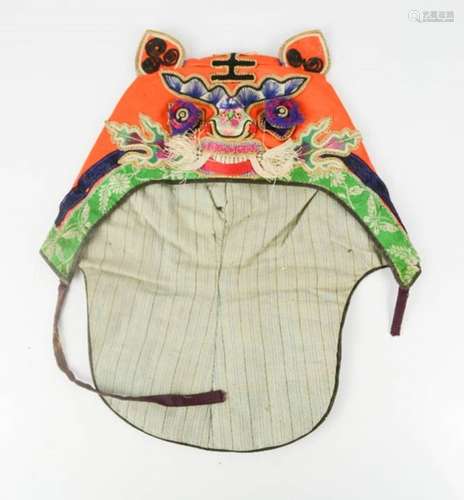 An early 20th century boy's tiger hat, embroidered with King character mark, symbolises the will