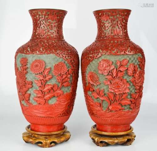 A pair of Chinese cinnabar and enamel vases on stands.