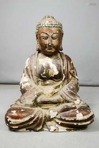 A large carved wooden buddha with residual polychrome.