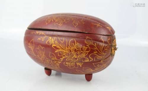 A red and gold painted Chinese box in the form of a nut/fruit.