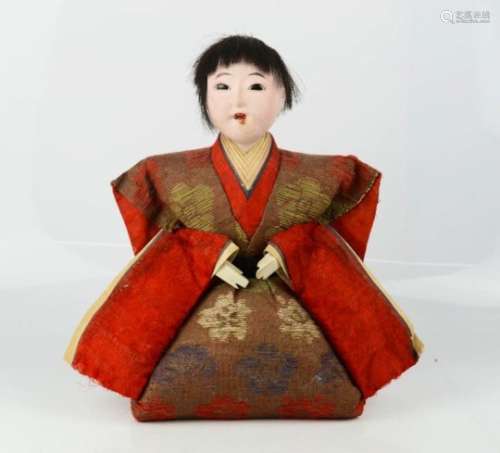 A Chinese doll, dressed in red and gold kimono.