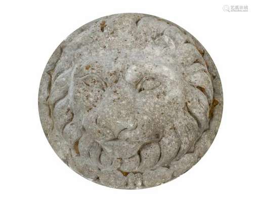 Lion Relief. Round stone plinth with lion head surrounded by leaves in half relief technique,