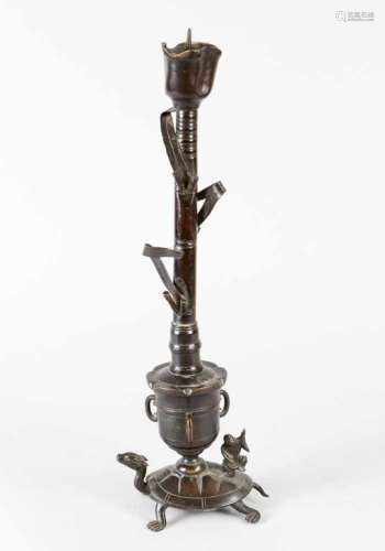 Asian candlestick in form of a flower with leaves on a vase with fantastic animals. Bronze cast with