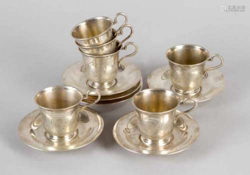 Six silver cups and saucers . Each with handgrip, flat body and stepped base. In the centre engraved