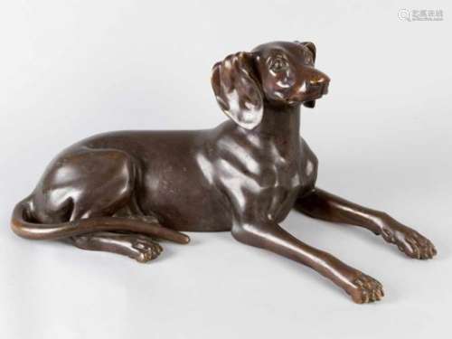 Bronze Dog, in lying position, original cast with light brown patina, early 20th Century.60 x 27 cm