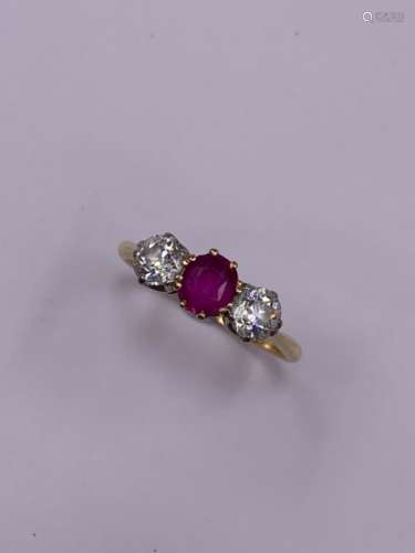 A UNMARKED GOLD RUBY AND DIAMOND THREE STONE CLAW SET RING. FINGER SIZE R, GROSS WEIGHT 2.6grms.