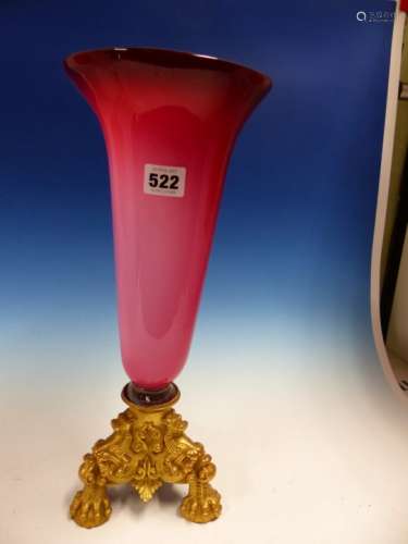 A TONED RUBY OVERLAID GLASS TRUMPET VASE FITTING INTO AN ORMOLU TRIPOD BASE. H 40cms