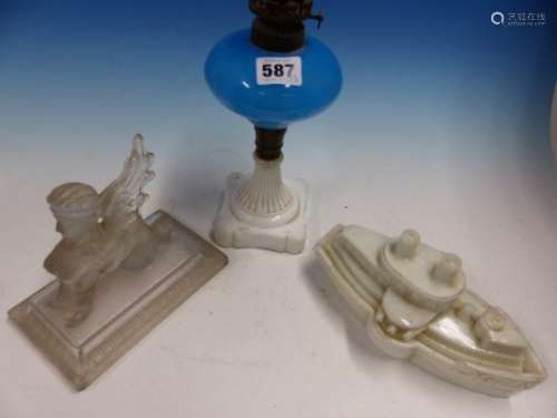 A MOULDED MILK GLASS BOX IN THE FORM OF THE BATTLESHIP MAIN. W 20cms AN OIL LAMP WITH THE BLUE GLASS