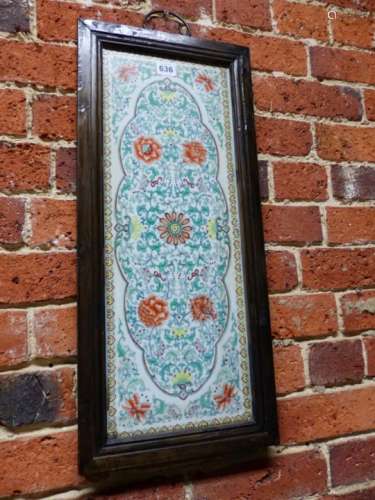 A FRAMED WUCAI PORCELAIN PANEL PAINTED WITH A WAVY EDGED OVAL OF SCROLLING FOLIAGE AND FLOWERS