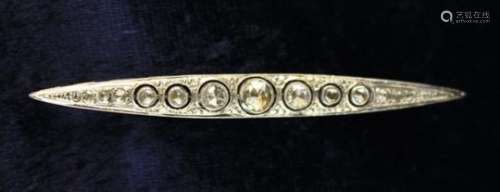 An Art Deco Diamond Bar Brooch set with seven graduated stones in an unmarked white metal enclosed