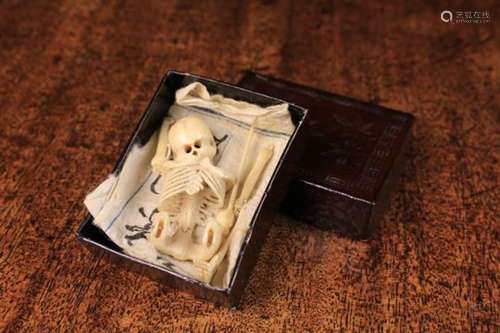 An Antique Carved Bone Miniature Skeleton with articulated limbs (A/F) in an oriental lacquered