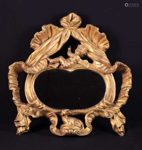 A 19th Century Oval Wall Mirror set in an open carved giltwood frame.