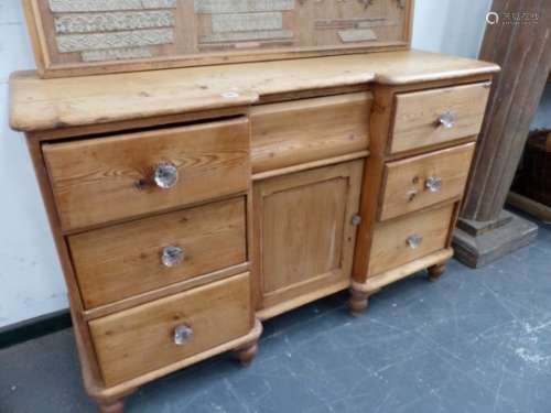 A VICTORIAN SMALL PINE DRESSER BASE WITH ARRANGEMENT OF SEVEN DRAWERS AND CUPBOARD CENTRE, ON TURNED
