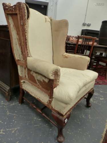AN ANTIQUE GEO.I.STYLE WING BACK ARMCHAIR ON CABRIOLE FORELEGS AND TURNED H-STRETCHER.