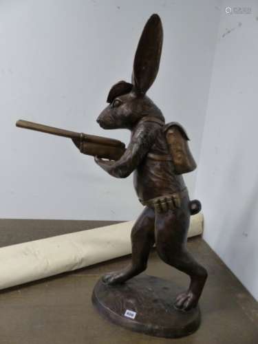 A LARGE CAST BRONZE ANTHROPOMORPHIC HARE CARRYING A SHOTGUN AND WEARING AN AMMO BELT AND HAT. H.