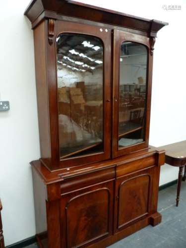 A VICTORIAN MAHOGANY BOOKCASE WITH GLAZED UPPER DOORS OVER TWO DRAWERS AND PANEL DOORS, ON PLINTH