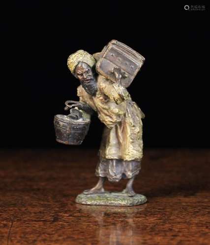 An Austrian Cold Painted Bronze Figure of an Arab man carrying a hat box & umbrella in one arm,