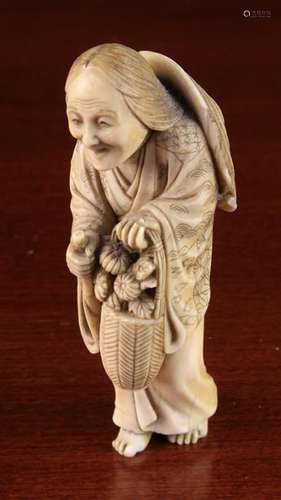 A 19th Century Signed Japanese Ivory Netsuke intricately carved as an elderly woman with bamboo