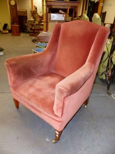 A VICTORIAN ARMCHAIR ON SQUARE TAPERED LEGS WITH BRASS CASTERS AND LATER PINK DRALON UPHOLSTERY.
