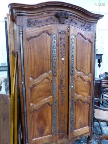 A FRENCH LOUIS XV WALNUT ARMOIRE WITH TWO SHAPED AND CARVED PANEL DOORS SUPPORTED ON FULL HEIGHT