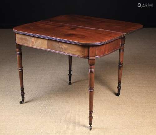 A George IV Mahogany Fold-over Tea Table standing on slender turned legs with brass caps & castors,