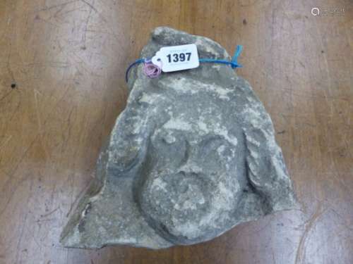 RETRIEVED FROM KENCOT, A 14th C. CARVED LIMESTONE HEAD WITH HAIR CURLED DOWN TO THE CHEEKS AND BELOW