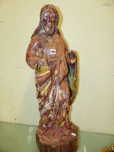 A CARVED WOOD, POSSIBLY LIMEWOOD, FIGURE OF A SAINT WITH REMNANTS OF POLYCHROME DECORATION. H.