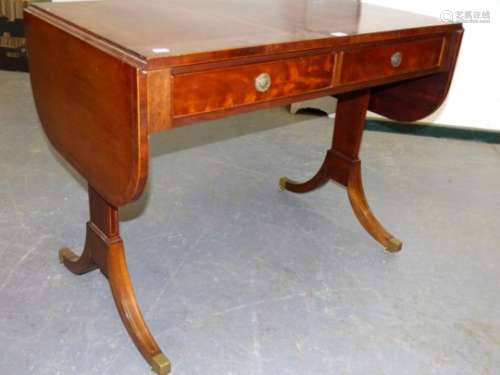 A GOOD QUALITY REGENCY STYLE MAHOGANY SOFA TABLE WITH LINE INLAY DECORATION ON BRASS CAP CASTERS.