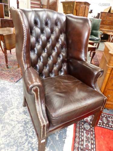 A BUTTON BACKED LEATHER WING ARMCHAIR ON MAHOGANY SHAPED SQUARE SECTIONED LEGS.