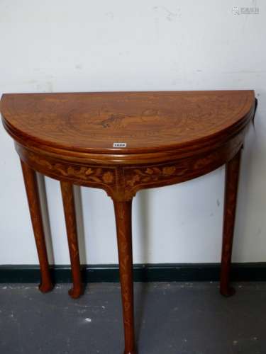 A MAHOGANY AND MARQUETRY INLAID TRIPLE TOP DEMI LUNE FOLD OVER GAMES TABLE ON TURNED LEGS WITH