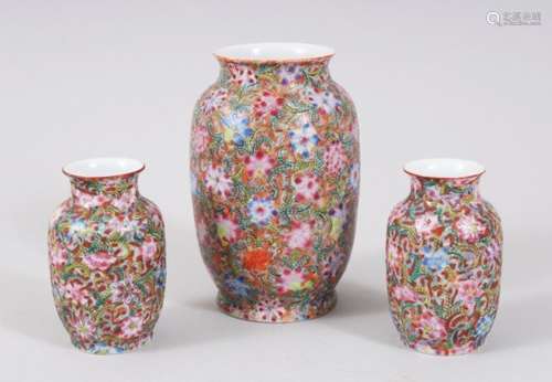 A GARNITURE OF THREE CHINESE EGGSHELL PORCELAIN FAMILLE ROSE VASES, with millefleur style