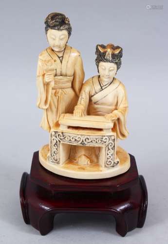 A 19TH CENTURY CHINESE CARVED IVORY FIGURE OF TWO LADIES, two ladies seated at a low table, one