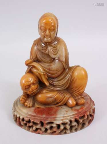 A VERY GOOD CHINESE CARVED SOAPSTONE FIGURE OF LOUHAN, completer with its hard stone carved base,