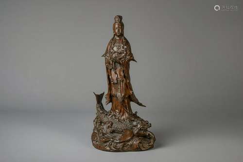 A Japanese bronze group depicting Kannon on a carp,