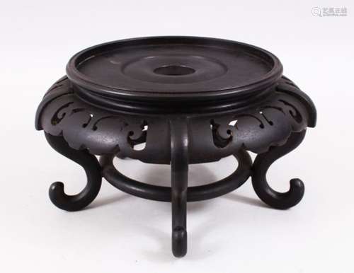 A CHINESE HARDWOOD CIRCULAR STAND ON FOUR CURVING LEGS, for a vase 7.5