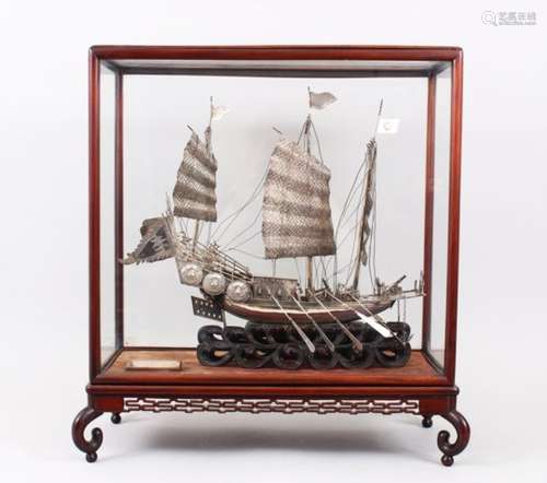 A LARGE 19TH CENTURY CHINESE SOLID SILVER WAR JUNK MODEL, the junk upon its wave style carved