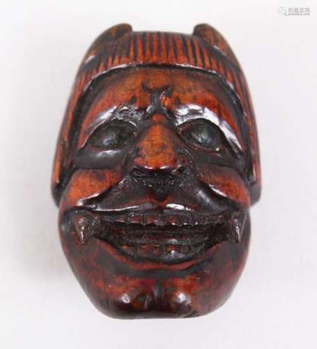 A GOOD JAPANESE EARLY MEIJI PERIOD CARVED WOODEN NETSUKE MASK OF AN ONI, with inlaid metal eyes,