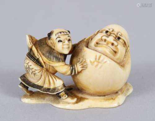 A LOVELY JAPANESE EDO PERIOD CARVED IVORY NETSUKE OF A CHINESE CHILD WITH A BIG DARUMA DOLL, the boy