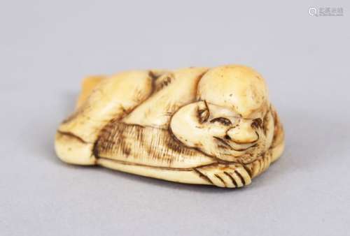 A LOVELY JAPANESE EDO PERIOD CARVED IVORY NETSUKE OF HOTEI, one of the seven lucky gods, led upon