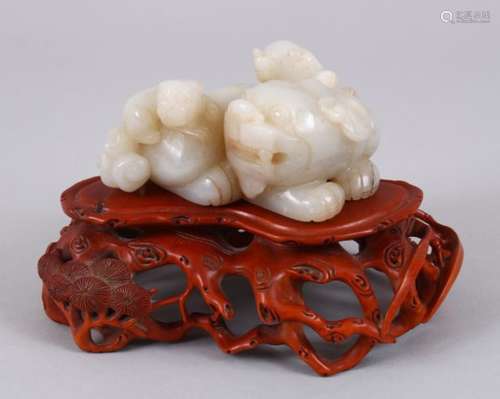 A GOOD CHINESE CARVED CELADON JADE KYLIN ON STAND, the kyling carved with two young upon its back,