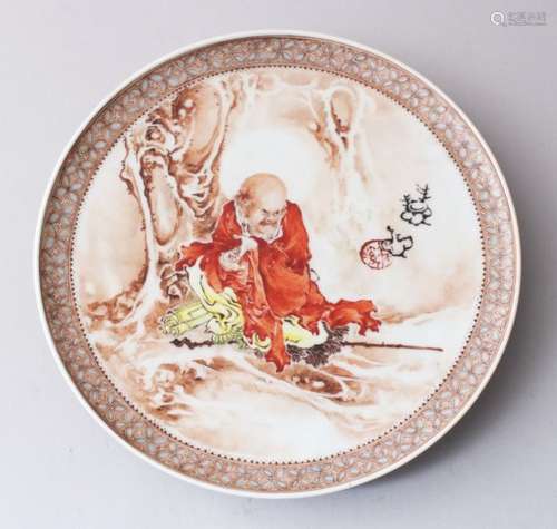 A CHINESE REPUBLICAN STYLE ENAMELLED PORCELAIN DISH, depicting scenes of a luohan resting under a