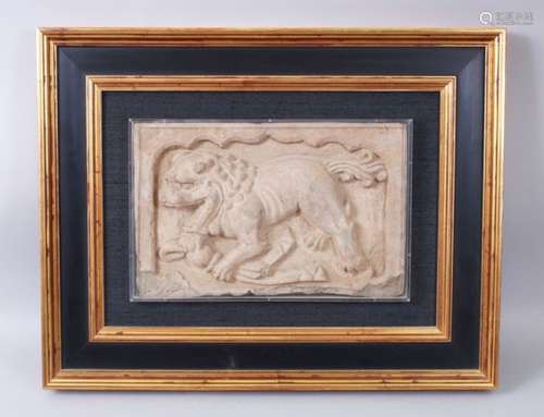 A CHINESE SANDSTONE RELIEF PANEL depicting a Buddhistic lion, framed. 20cms x 31cms.